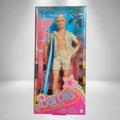 Ken Barbie The Movie con conjunto playero de rayas y tabla de surf